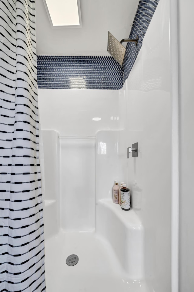 bathroom with a skylight and a shower