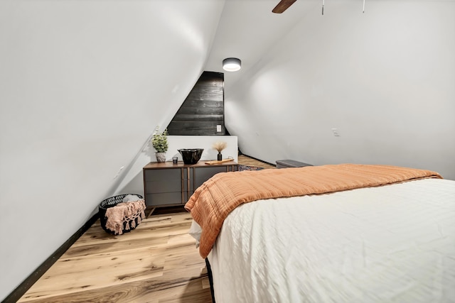 bedroom featuring ceiling fan, light wood finished floors, and vaulted ceiling