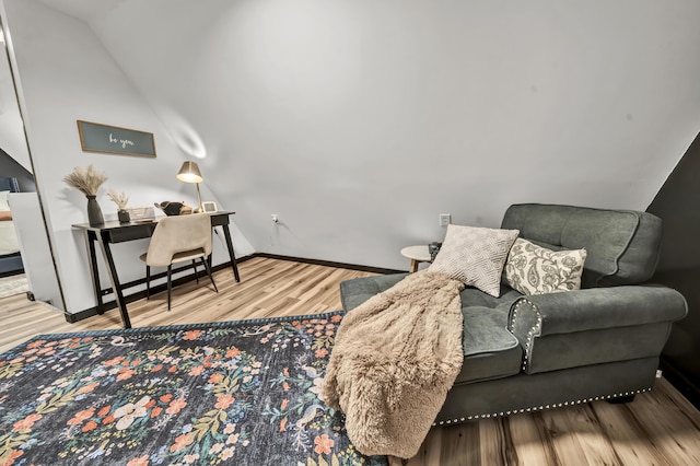 living area with lofted ceiling, wood finished floors, and baseboards
