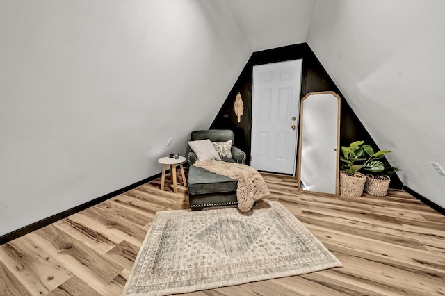 living area with lofted ceiling, wood finished floors, and baseboards