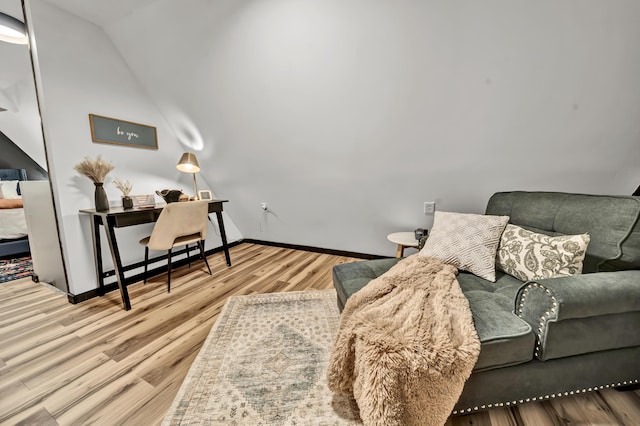 living area with wood finished floors and vaulted ceiling