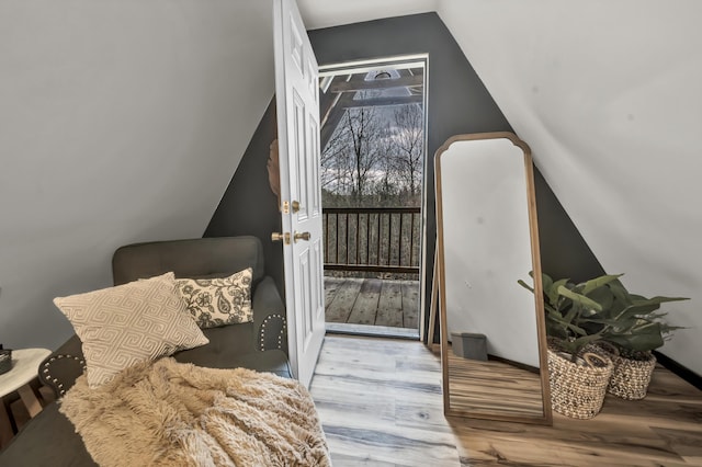 interior space featuring vaulted ceiling, wood finished floors, and baseboards