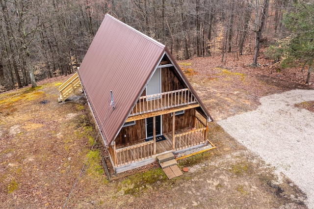 view of front of house with a wooded view and metal roof