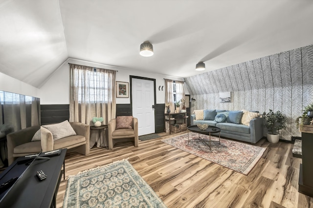 living room featuring wood finished floors, a wainscoted wall, and vaulted ceiling
