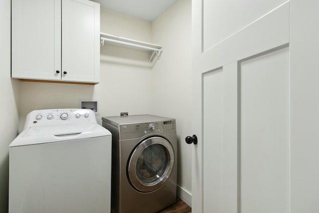 washroom featuring cabinet space, wood finished floors, and washer and dryer