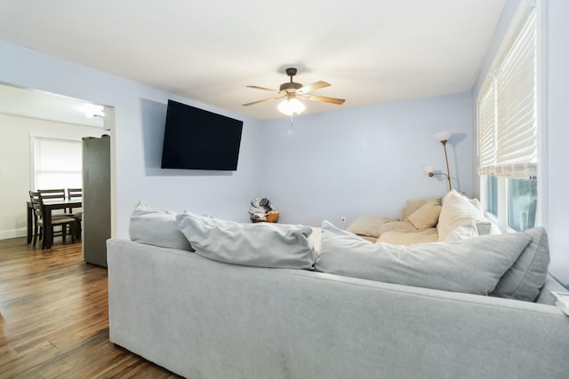 living room featuring a ceiling fan and dark wood-style flooring