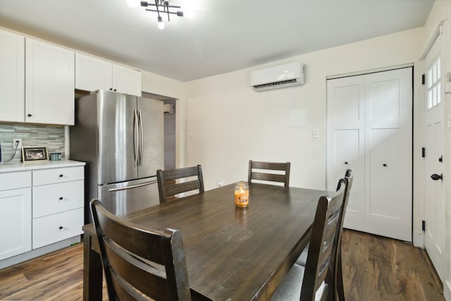 dining space with an AC wall unit and dark wood finished floors
