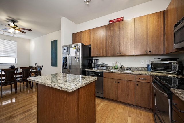 650 S Mill St Unit 219, Lexington, KY 40508 - kitchen featuring stainless steel appliances, a sink, light wood-type flooring, ceiling fan, and a kitchen island