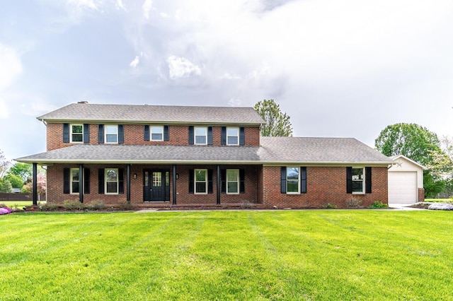 view of front of property featuring brick siding, a shingled roof, a front yard, and a garage