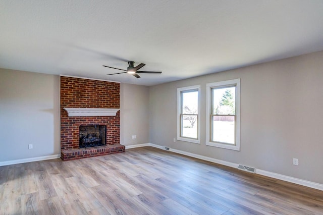 unfurnished living room with baseboards, a ceiling fan, wood finished floors, and visible vents
