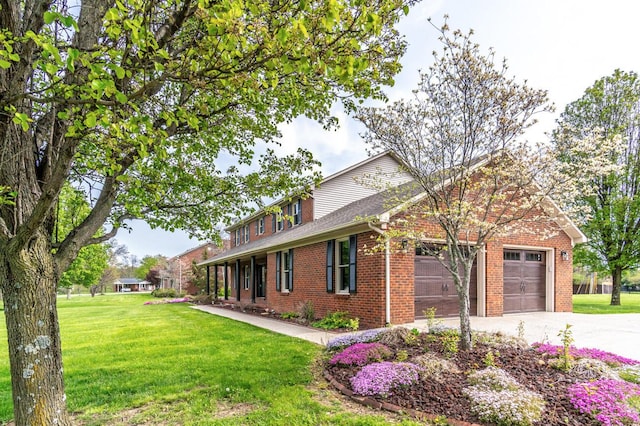 traditional-style home featuring a garage, brick siding, a front yard, and concrete driveway