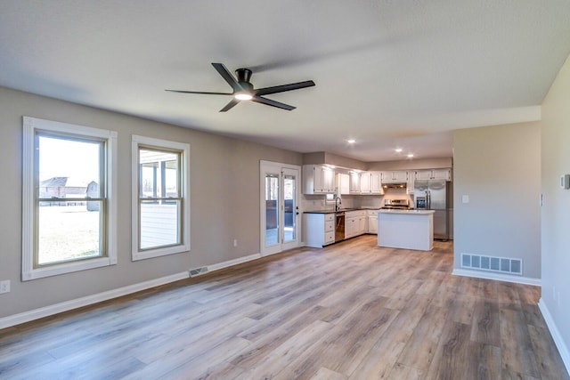 kitchen featuring a sink, open floor plan, visible vents, ceiling fan, and appliances with stainless steel finishes
