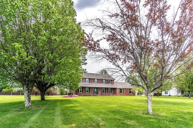 traditional-style house featuring brick siding and a front yard