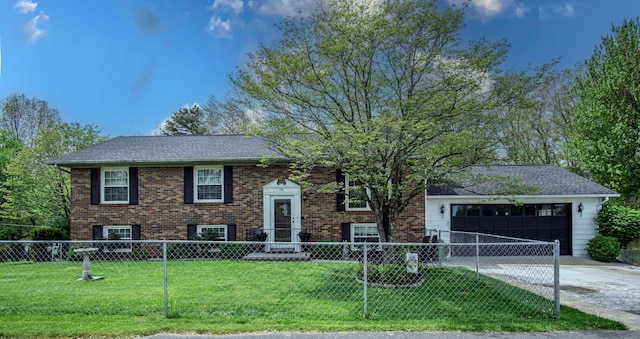 raised ranch featuring a fenced front yard, driveway, brick siding, a front yard, and a garage