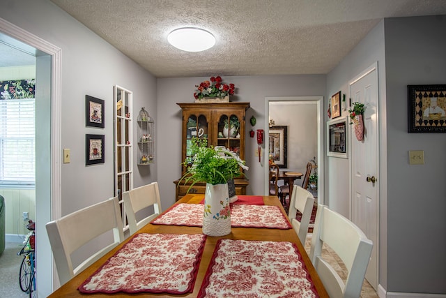dining space with baseboards and a textured ceiling