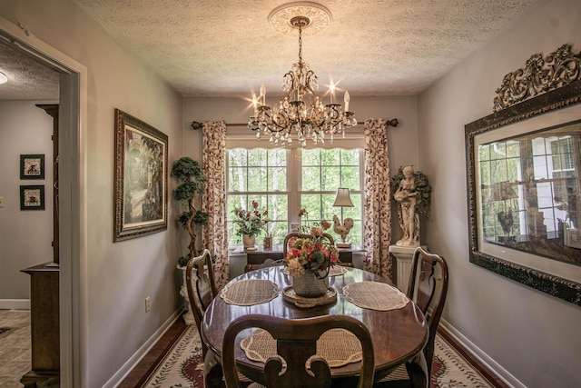 dining space with baseboards, an inviting chandelier, and a textured ceiling