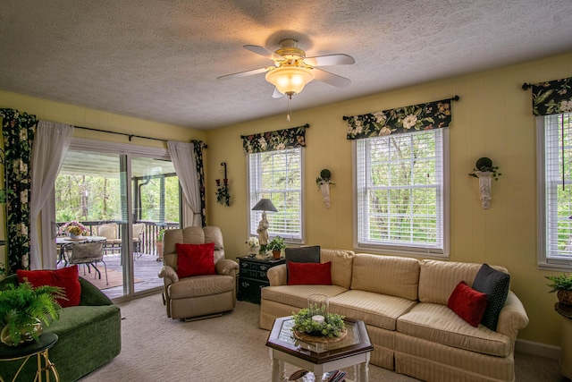 carpeted living area with a textured ceiling and a ceiling fan