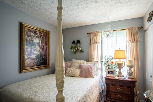 bedroom featuring a chandelier and a textured ceiling