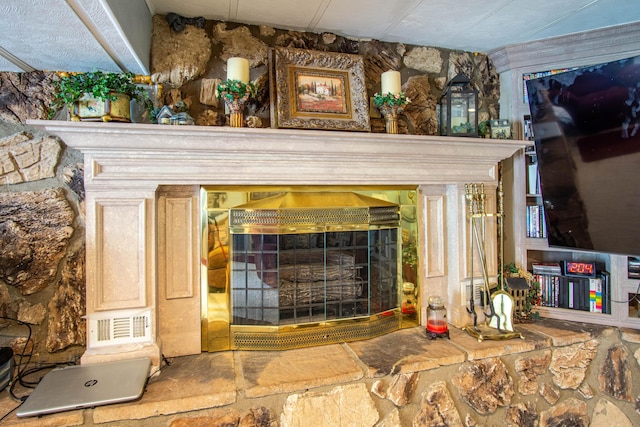 details with a fireplace with raised hearth and visible vents