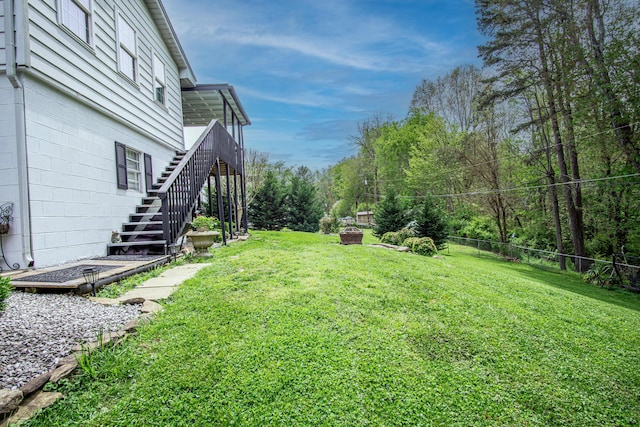 view of yard with fence and stairs