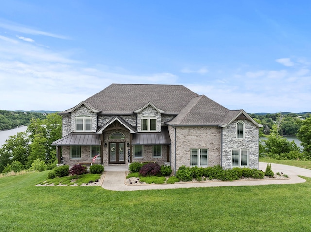 craftsman-style home with a standing seam roof, a front yard, french doors, and roof with shingles