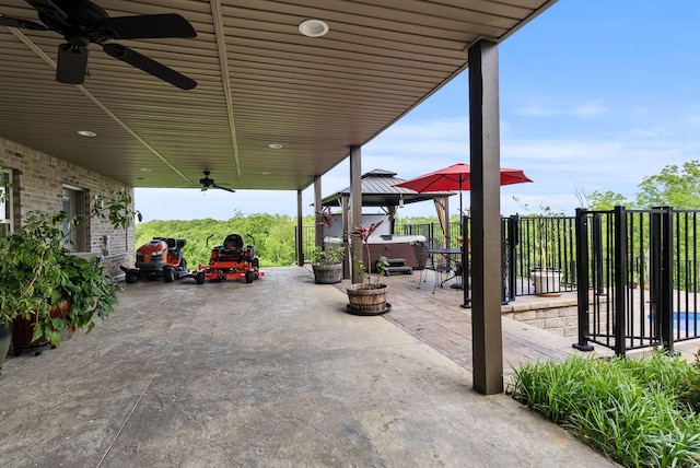 view of patio / terrace featuring a ceiling fan, a gazebo, a hot tub, and fence