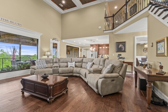 living area with a towering ceiling, dark wood-style floors, baseboards, recessed lighting, and ornamental molding