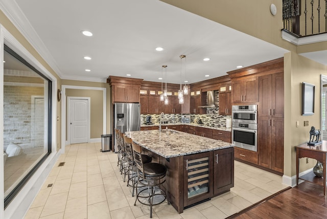 kitchen with wall chimney range hood, beverage cooler, appliances with stainless steel finishes, glass insert cabinets, and backsplash
