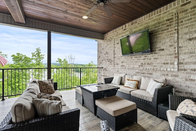 wooden terrace with an outdoor living space and ceiling fan