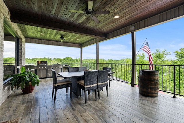 deck featuring ceiling fan, an outdoor kitchen, outdoor dining space, and grilling area