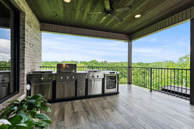 wooden terrace featuring ceiling fan and exterior kitchen