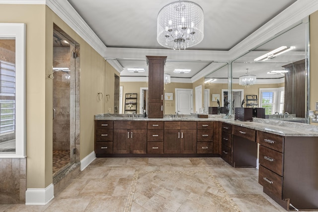 full bathroom featuring a chandelier, ornamental molding, a shower stall, decorative columns, and vanity