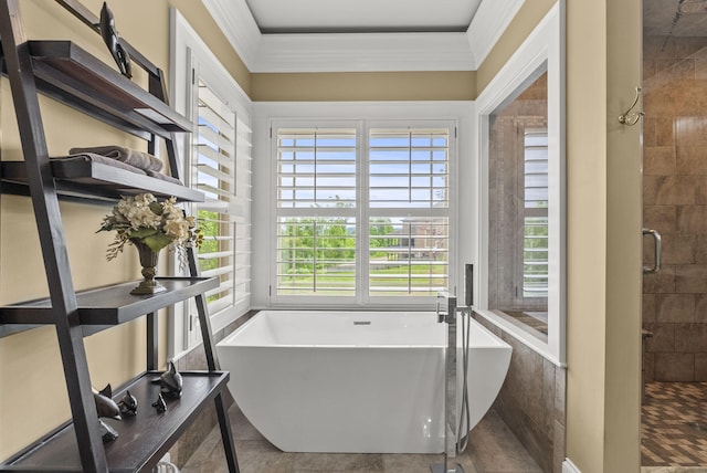bathroom with crown molding, a tile shower, and a freestanding bath
