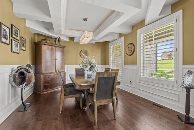 dining space featuring wainscoting, a decorative wall, and dark wood-style flooring