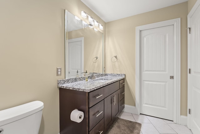 bathroom with tile patterned floors, toilet, vanity, and baseboards