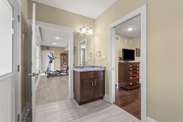 bathroom with vanity, baseboards, and wood finish floors