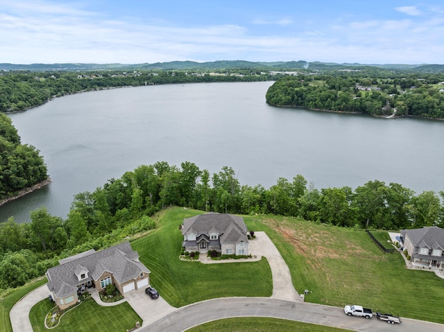 view of subject property featuring a nearby body of water and a heavily wooded area