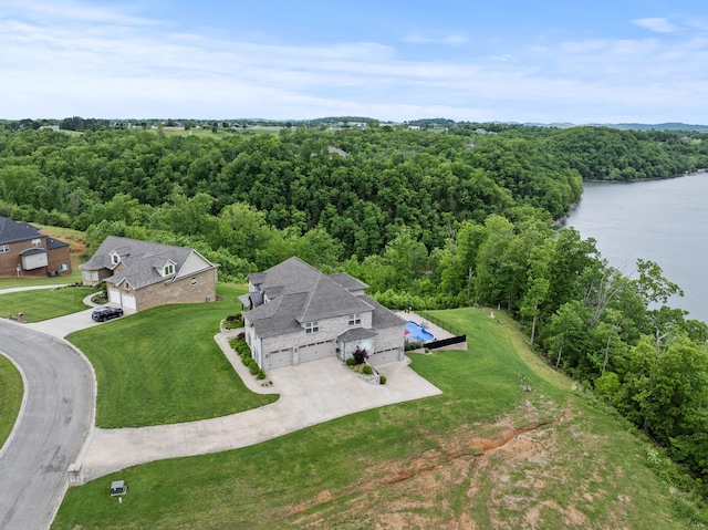 view from above of property with a forest and a nearby body of water