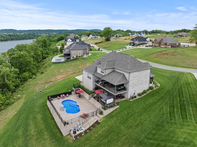 aerial view of property and surrounding area featuring a pool and a nearby body of water