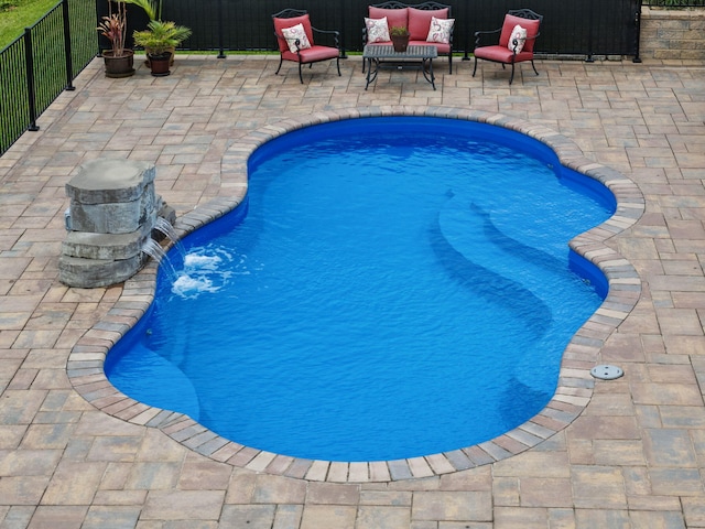 view of swimming pool featuring a patio, fence, and an outdoor living space