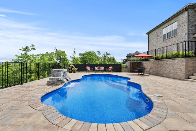 view of pool with a patio, fence, and an outdoor hangout area