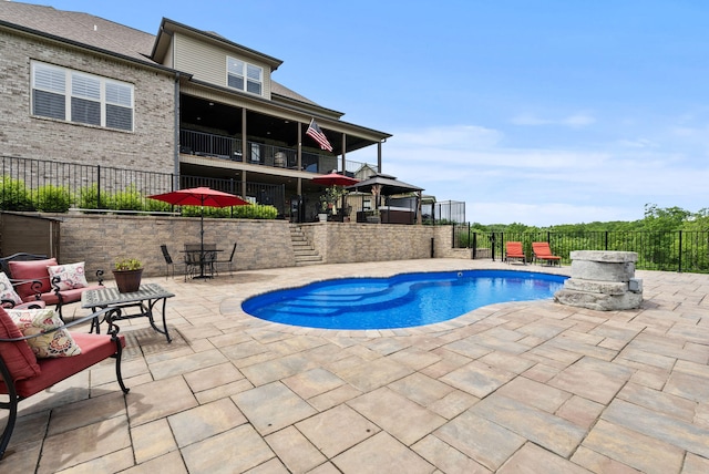 view of pool featuring a patio, stairway, fence, an outdoor hangout area, and outdoor dining space