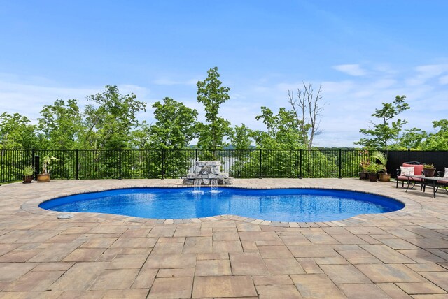 view of swimming pool featuring a patio and fence