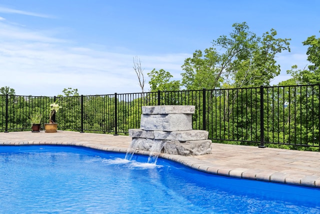 view of swimming pool with fence and a patio
