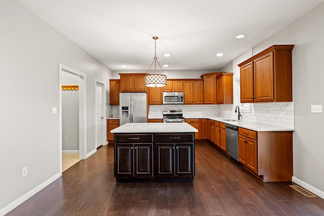 kitchen featuring brown cabinets, stainless steel appliances, light countertops, and a sink
