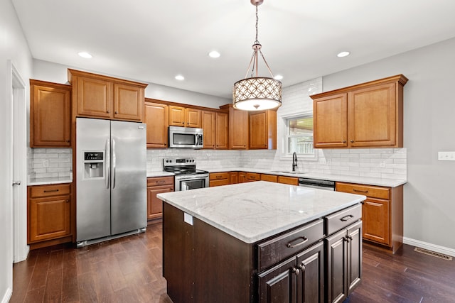 kitchen with dark wood-style floors, visible vents, a sink, tasteful backsplash, and appliances with stainless steel finishes