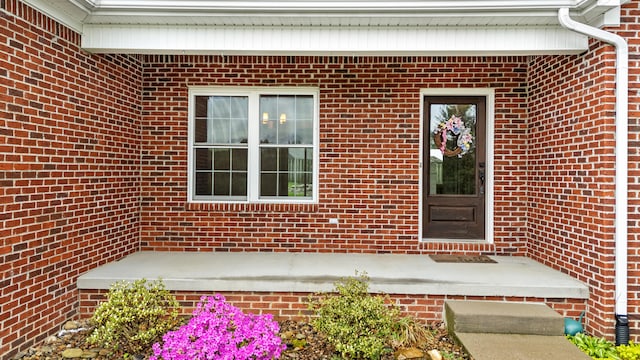 view of exterior entry with brick siding