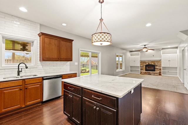 kitchen featuring a ceiling fan, stainless steel dishwasher, dark wood-style flooring, and a sink