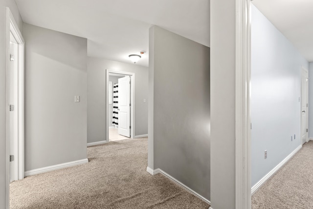 hallway with baseboards and carpet flooring