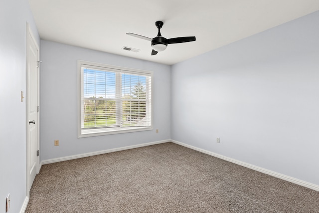 unfurnished room with carpet, visible vents, baseboards, and ceiling fan